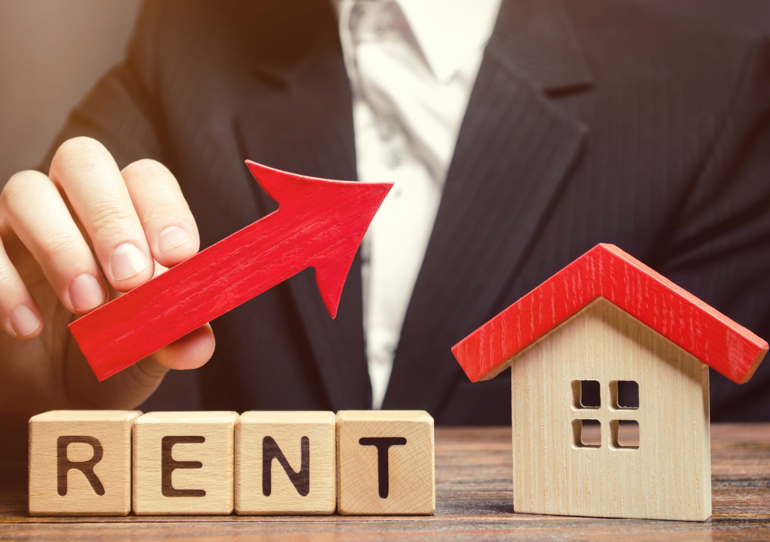 Wooden blocks with the word Rent, house and up arrow. The concept of the high cost of rent for an apartment or home. Interest rates are rising. Real estate market. Increased demand for rental property