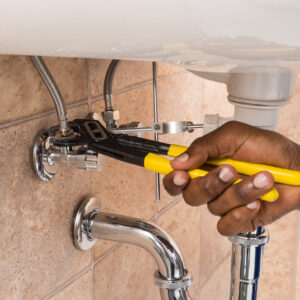 Close-up Of Plumber's Hand Repairing Sink In Bathroom